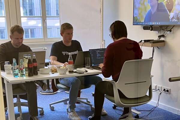 Ein Team arbeitet zusammen an ihren Laptops