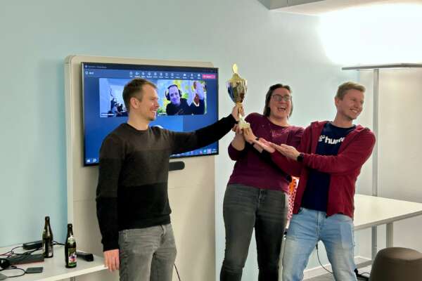 Das Gewinnerteam hält zusammen einen Pokal hoch