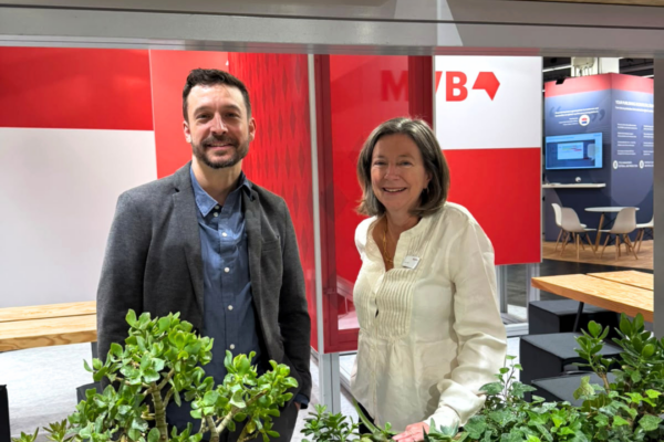 Two MVB-colleagues at the mvb-booth behind flower boxes.