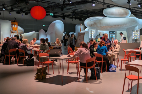 People sit at desks in the pavillion of guest land Czech Republic with huge inflatable element that are meant to represent stones at the coast.